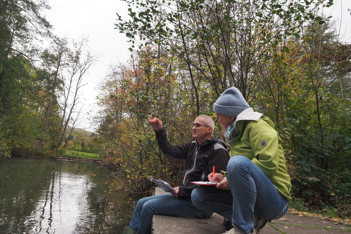Zwei Personen beraten sich am Weiher