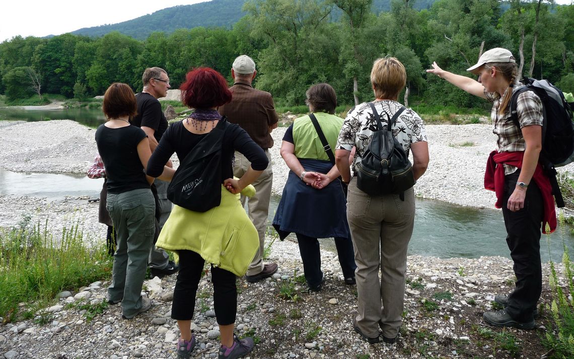 Eine Gruppe auf einer Führung am Flussufer