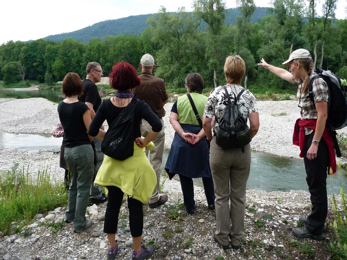 Eine Gruppe auf einer Führung am Flussufer