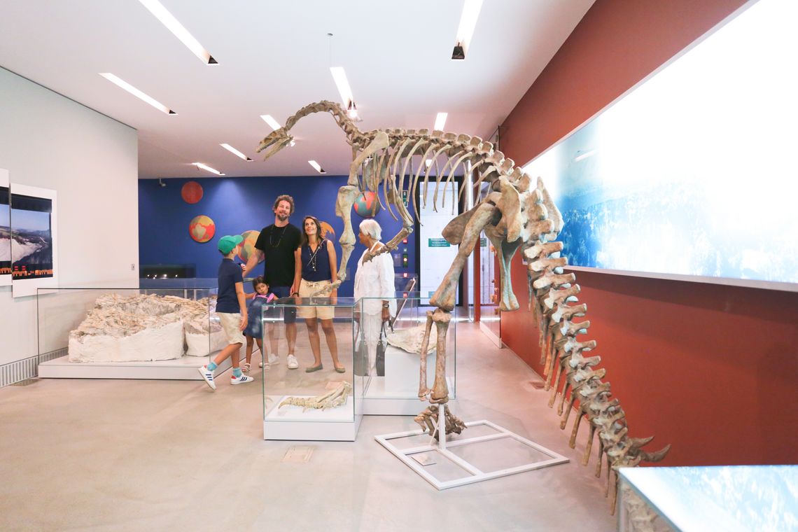 Familie erkundet Museum mit Dinosaurierskelett